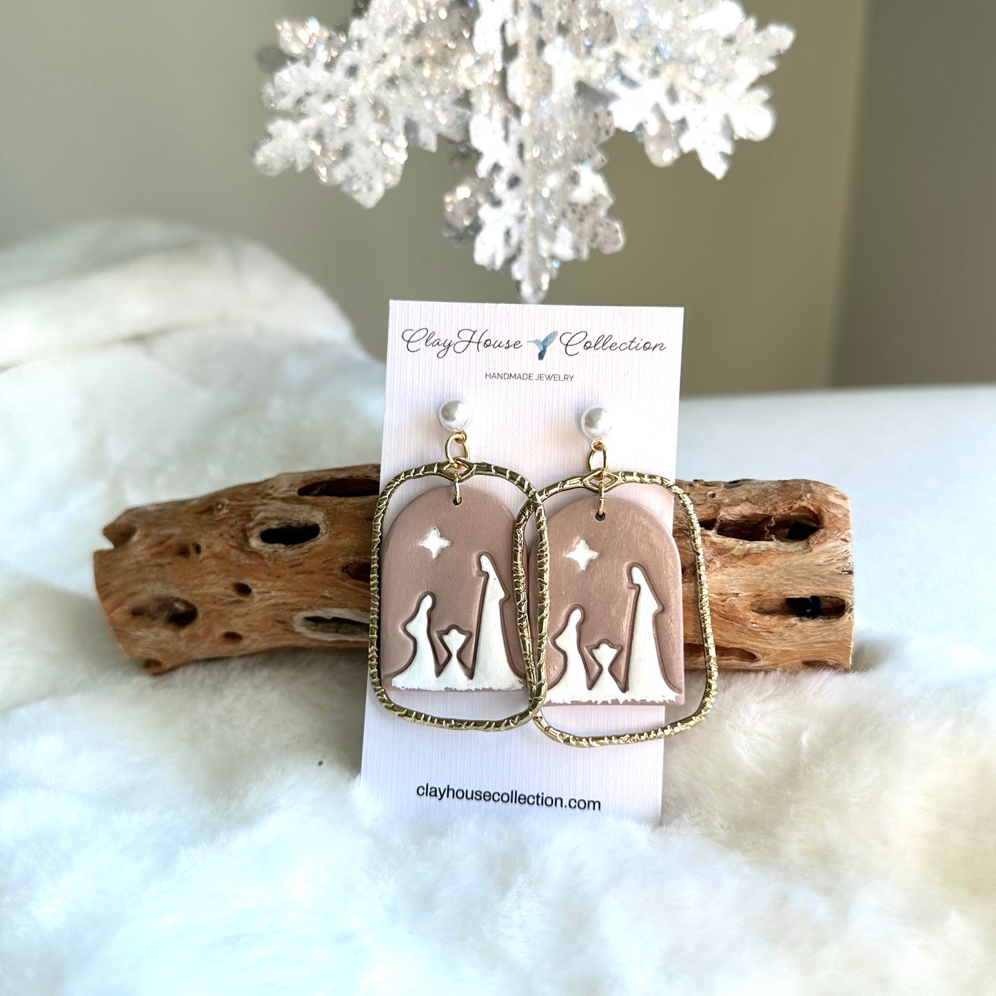 Earrings on a Clayhouse Collection card with driftwood and white coral in the background