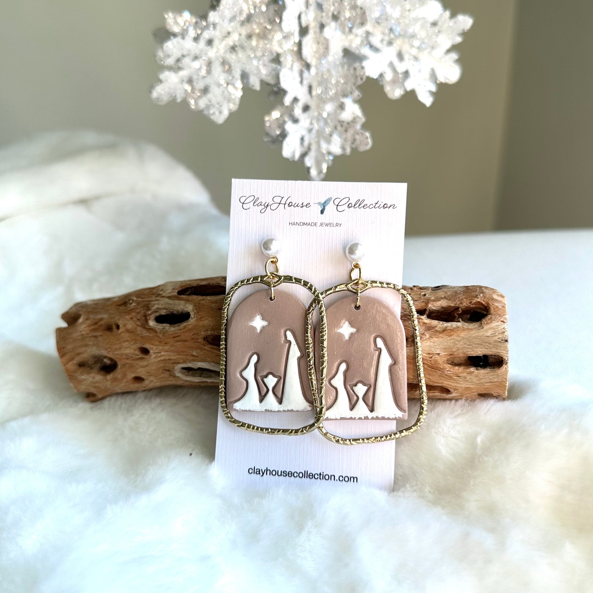 Earrings on a Clayhouse Collection card with driftwood and white coral in the background