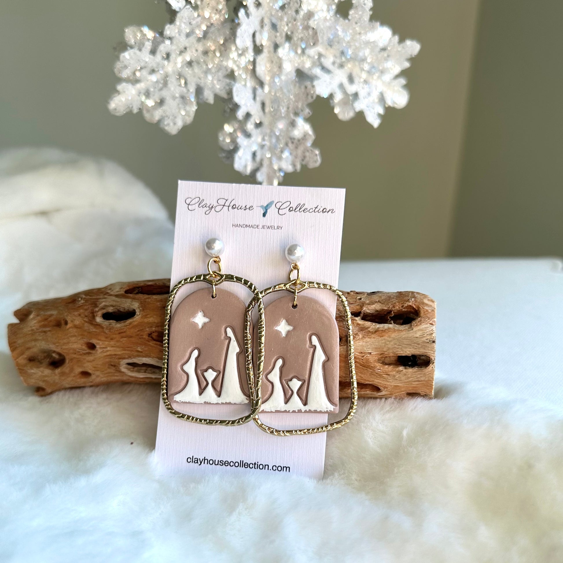 Earrings on a card with 'Clay House Collection' branding, displayed on a soft white surface with decorative elements.