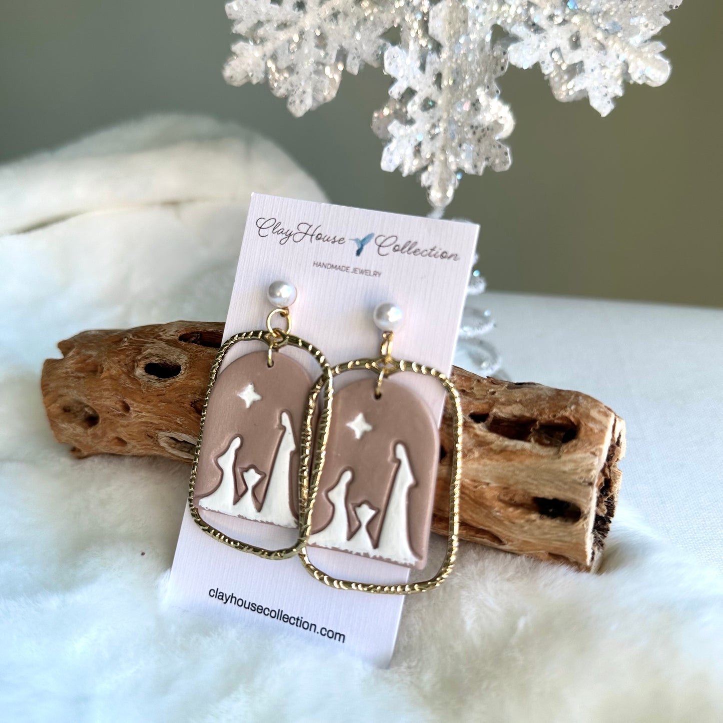 Pair of earrings on a Clay House Collection card with a snowy background