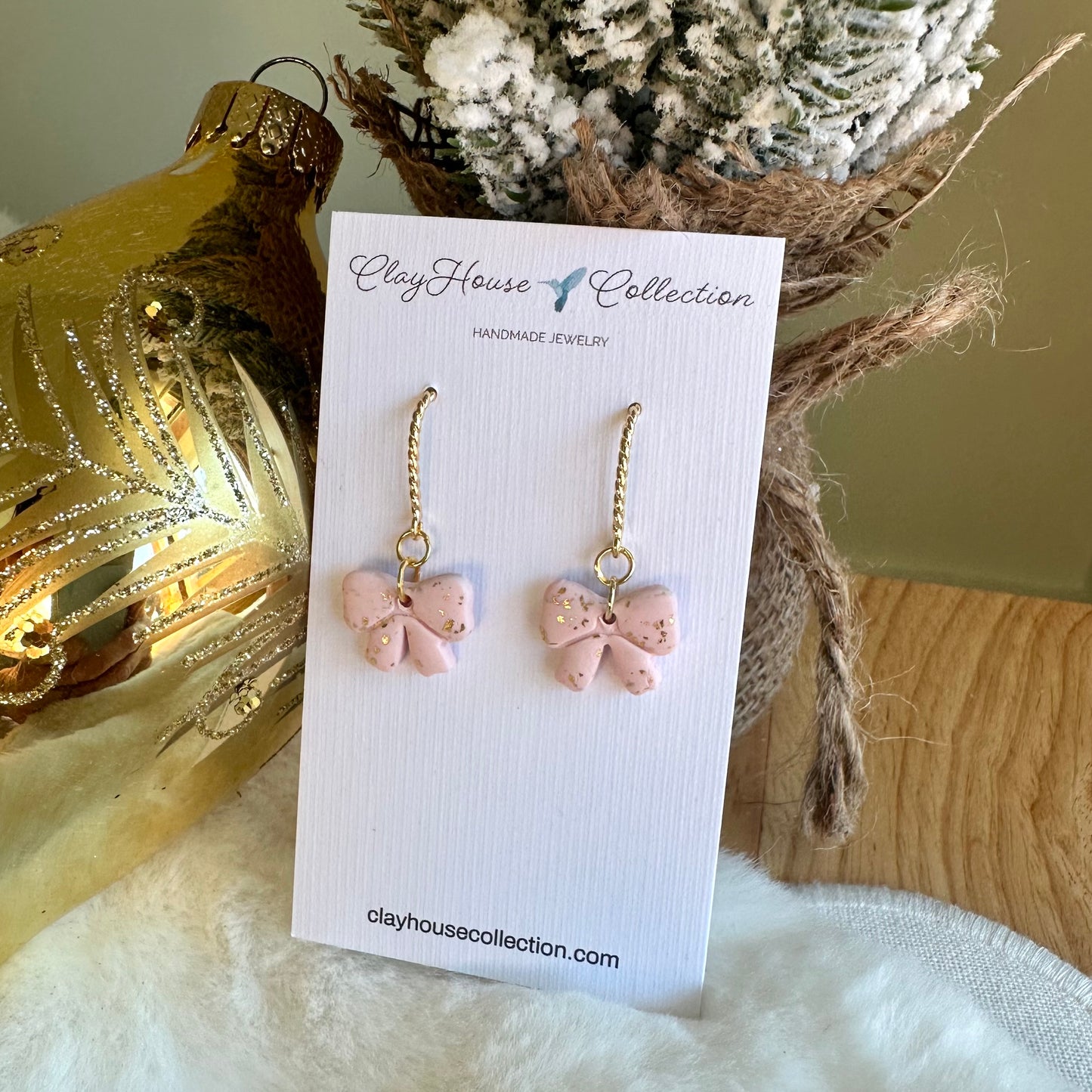 Pink butterfly earrings on a ClayHouse Collection card with decorative background